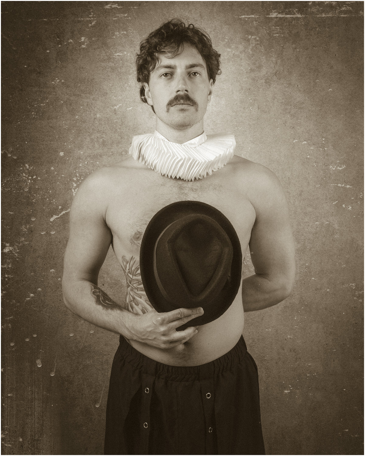 Portrait sépia d’un homme moustachu, torse nu, portant une collerette blanche et tenant un chapeau sombre devant lui, sur fond vieilli. Portrait Retrouvé 1837 – III, par SchaPicShow.